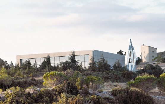 Bâtiment contemporain et sculpture moderne à Château de Lastours, entourés de garrigue
