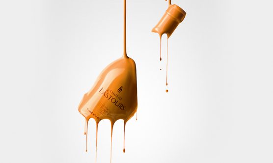 Bouteille de vin Château de Lastours recouverte de peinture orange, en suspension