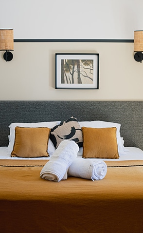 Lit double préparé avec serviettes dans une chambre élégante de la Villa Lastours