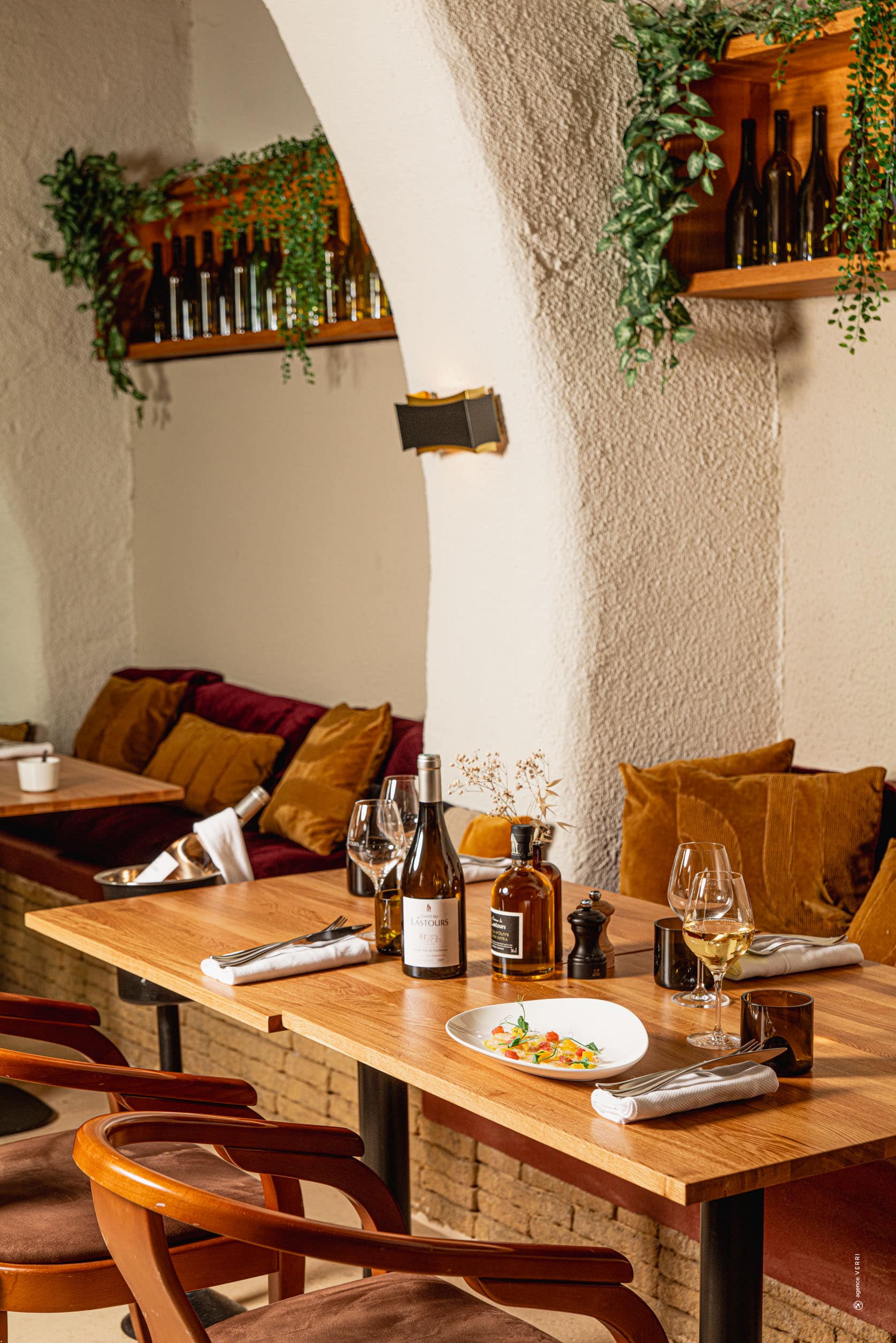 Table élégamment dressée au restaurant du Château de Lastours avec vin blanc et plat gastronomique